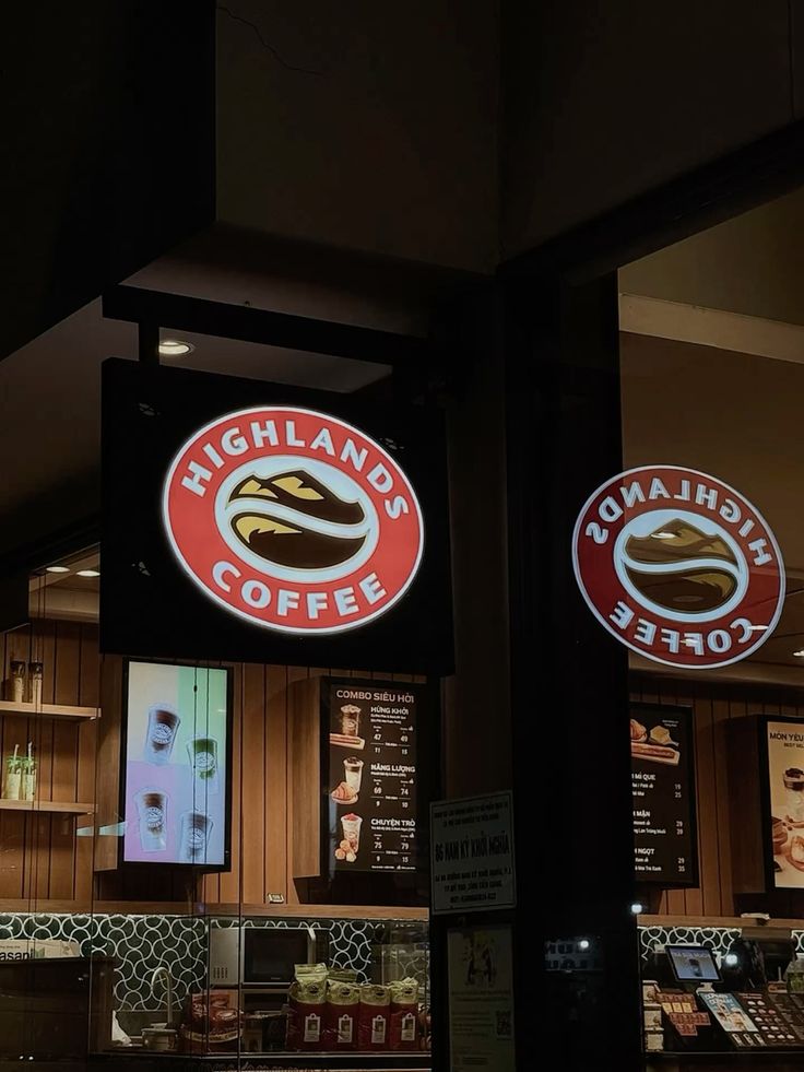 Highlands Coffee shop exterior with warm lights and wooden seating