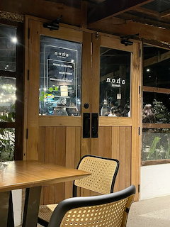 Coffee shop interior with wooden framed glass doors and woven chairs