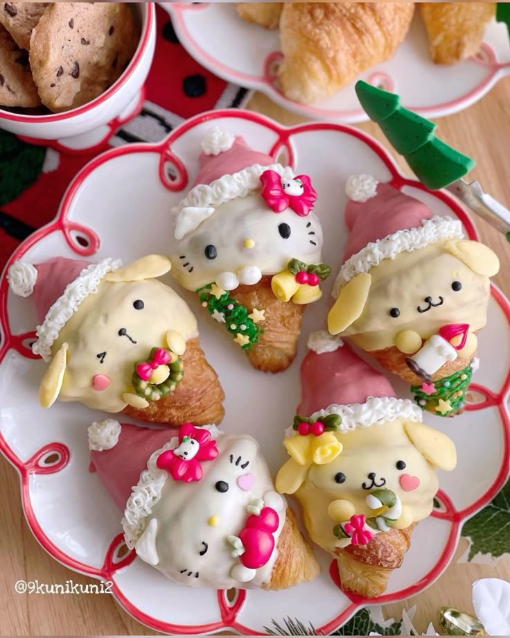 Hello Kitty and Pompompurin character-shaped Christmas pastries with Santa hats and wreaths on a white plate