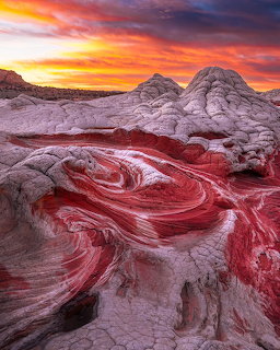 Swirling red and white sandstone formations at White Pocket, Arizona, with colorful sunset sky