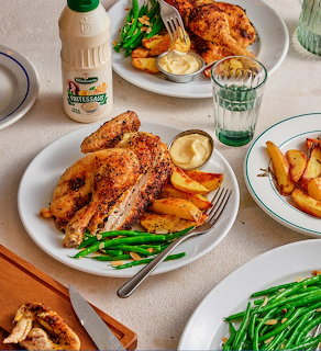 Roasted chicken with potato wedges and green beans on white plates