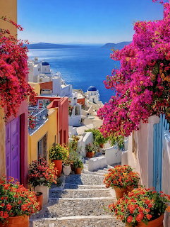Stone stairway lined with pink flowers between colorful buildings overlooking coastal sea