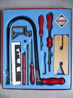 Vintage boxed toy tool set with red-handled tools on blue backing