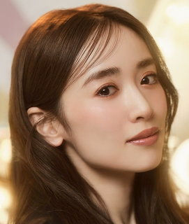Close-up portrait of a woman with long brown hair and a soft expression