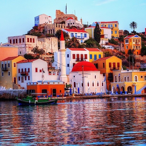 Colorful hillside buildings overlooking calm water at sunset in Capri