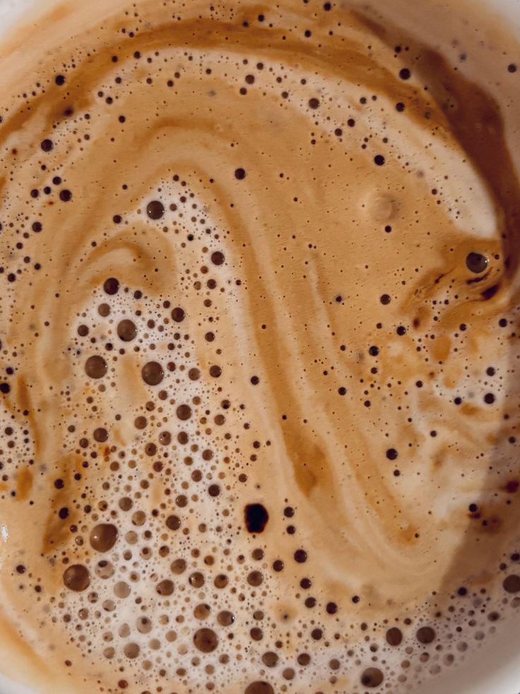 Close-up of foamy coffee surface with swirls and bubbles