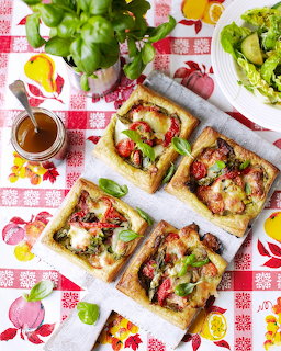 Four savory vegetable tarts with mushrooms, tomatoes and basil on puff pastry, arranged on checkered cloth
