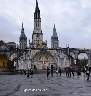 Large church with three spires and a wet open plaza with people in front