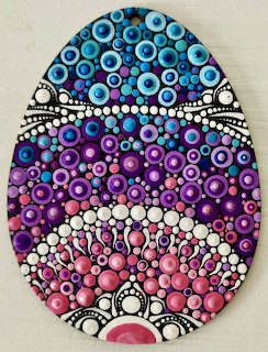 Easter egg with intricate dot mandala pattern in blue, purple, and pink hues