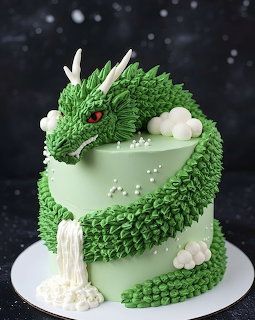 Green dragon cake coiled around a pale mint tier on a white cake stand