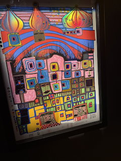 Colorful Hundertwasser-style painting of fantastical buildings with onion domes and geometric patterns