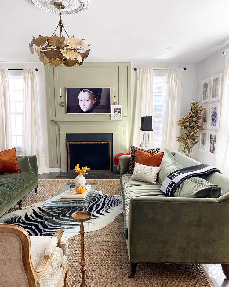 Cozy living room with green sofas, fireplace, zebra rug, and TV above the mantel