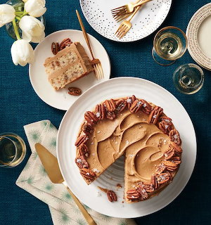 Overhead view of a butter toffee pecan layer cake with slices on plates and champagne glasses