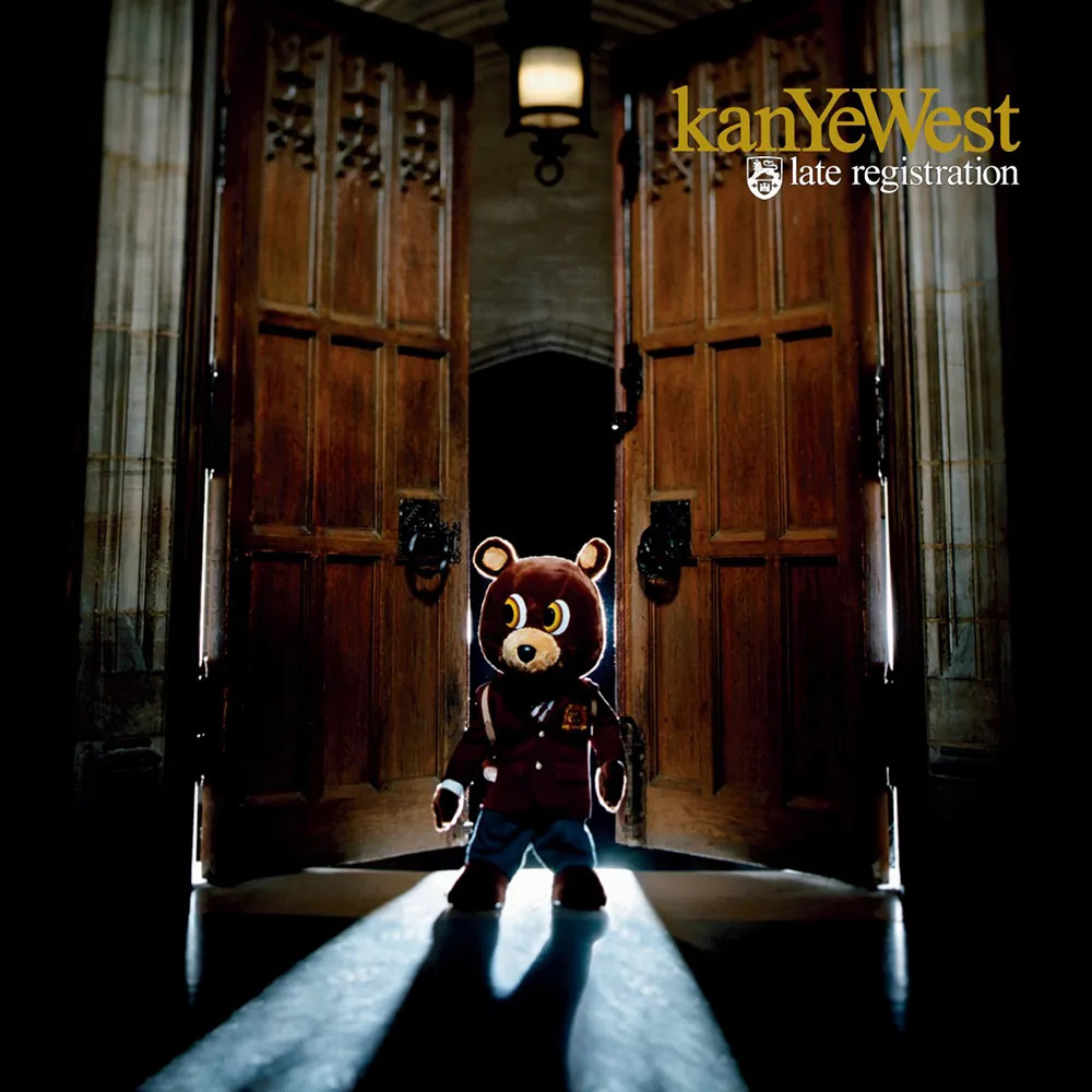Album cover with a teddy bear figure in a doorway, lit by beams of light in a dark hallway.