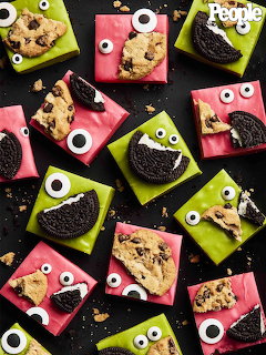 Halloween brownies with candy eyes and Oreo cookies on pink and green wrappers arranged on black background