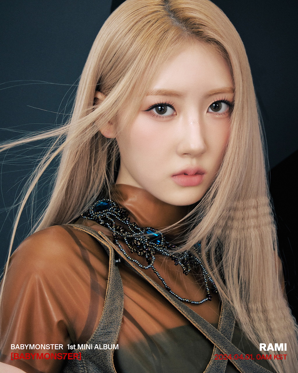 Close-up portrait of Rami from BABYMONSTER with flowing blonde hair and ornate necklace
