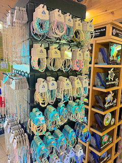 Store display rack with rows of colorful beaded necklaces and bracelets in turquoise and pastel colors