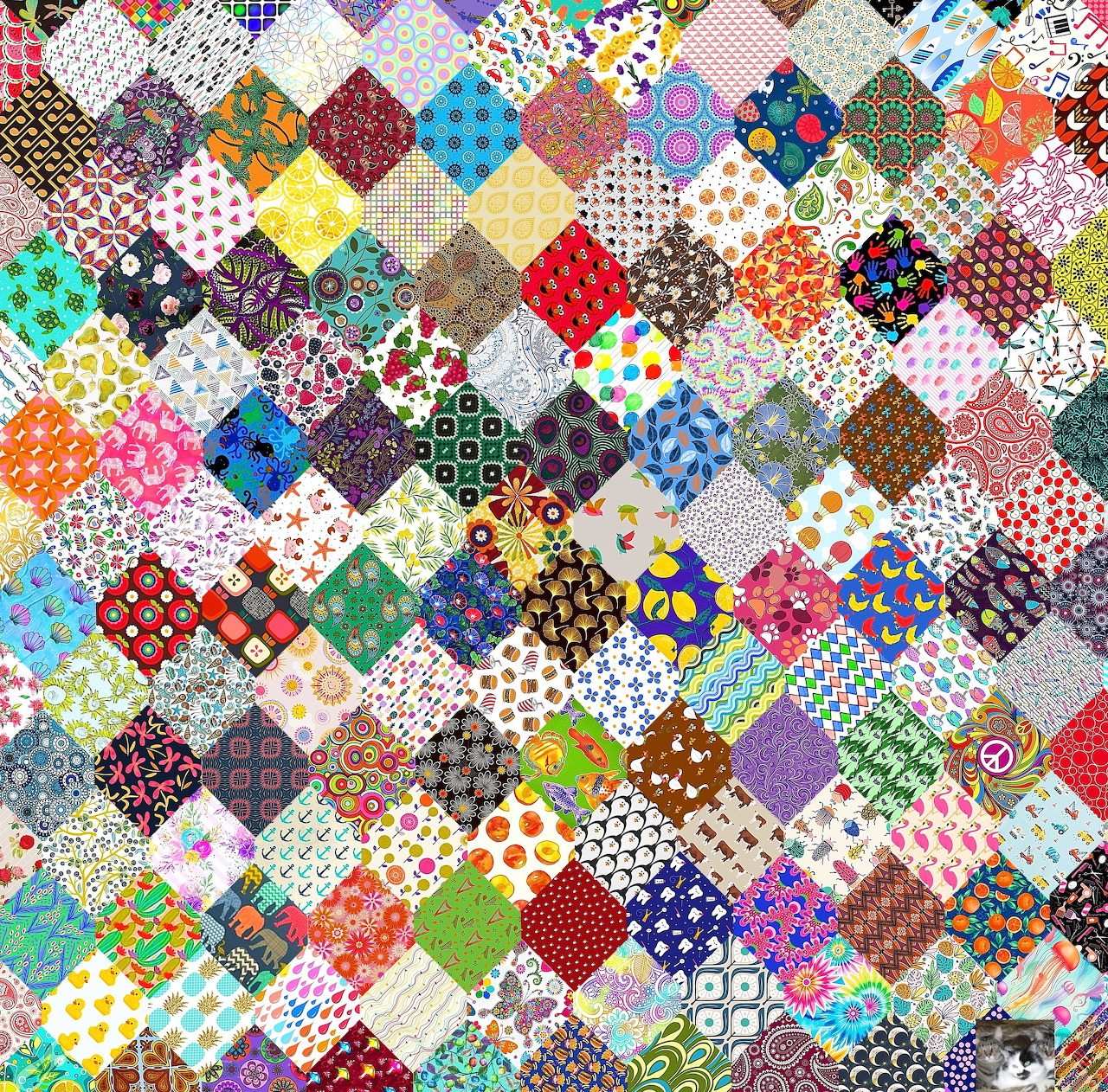 Colorful hexagonal patchwork quilt with mixed fabric patterns including florals, dots, and geometric designs