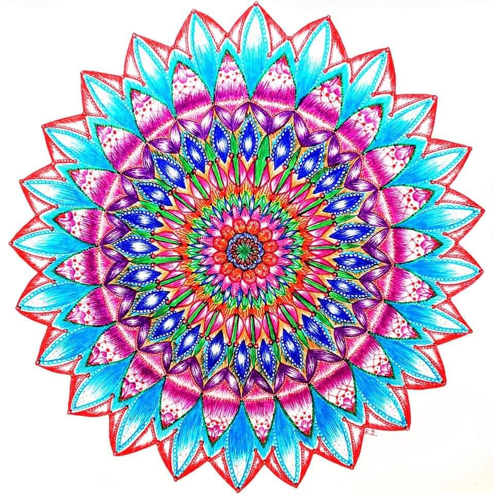 Symmetrical mandala with multicolored petals radiating from ornate center in pink, turquoise, purple, and orange