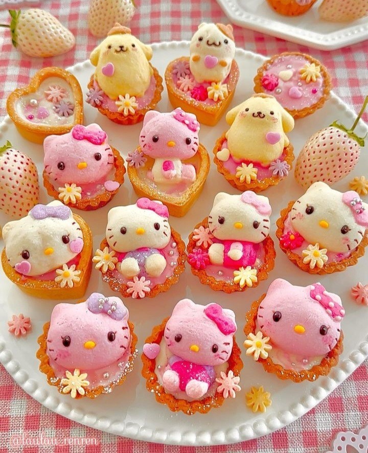 Plate of kawaii character pastries with pink and yellow icing and cute decorations on checkered tablecloth