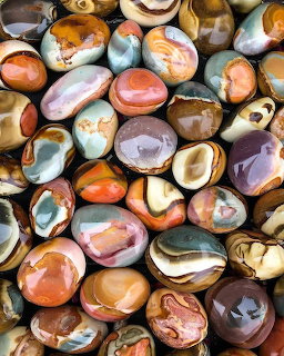 Assortment of polished agate stones with natural banding in orange, brown, and cream colors