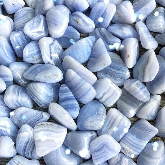 Collection of smooth blue and white striped agate stones arranged closely together