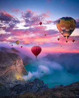 Hot air balloons drifting over ocean cliffs at sunset with vibrant pink and purple sky