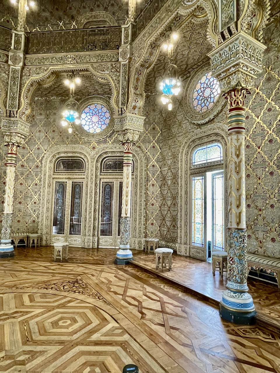 Elaborate gold Arab Room interior with intricate patterns, parquet floor, arched windows and ornate ceiling