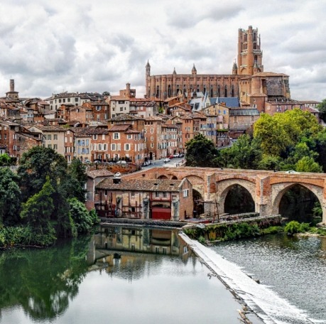 View of Albi, France with medieval bridge over Tarn River and Sainte-Cécile Cathedral in background