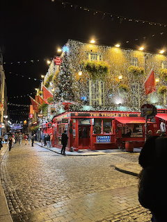 Temple Bar pub in Dublin at night with Christmas lights and cobblestone street