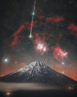 Comet and red Orion Nebula in stary night sky above snow-capped Mount Taranaki volcano