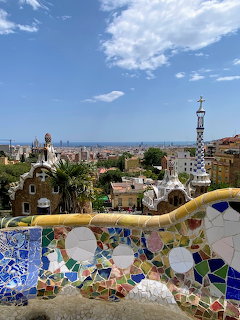 Mosaic terrace at Parc Guell overlooking Barcelona under a blue sky