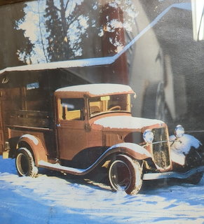 Brown vintage pickup truck covered in snow parked outside in winter