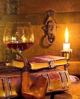 Stack of antique books with a pipe, lit candle, and glass on a wooden table