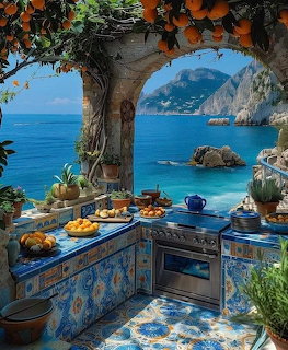Blue ceramic tiled kitchen with sea view, hanging oranges, and coastal landscape beyond arched opening