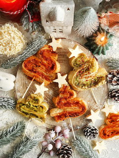 Star-shaped savory pastry with six sections of different fillings surrounded by Christmas decorations and pine branches