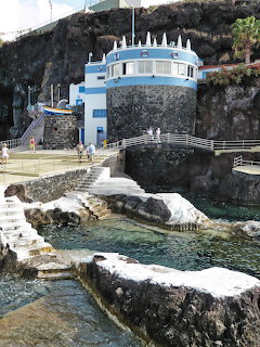 White and blue coastal bathing complex with natural rock pools and cliff backdrop in Funchal, Madeira