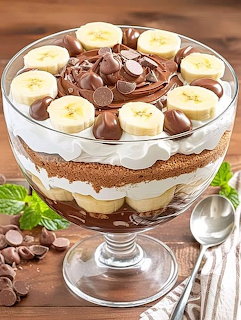 Chocolate banana trifle with layers of pudding, cream, banana slices, and chocolate wafers in glass dish