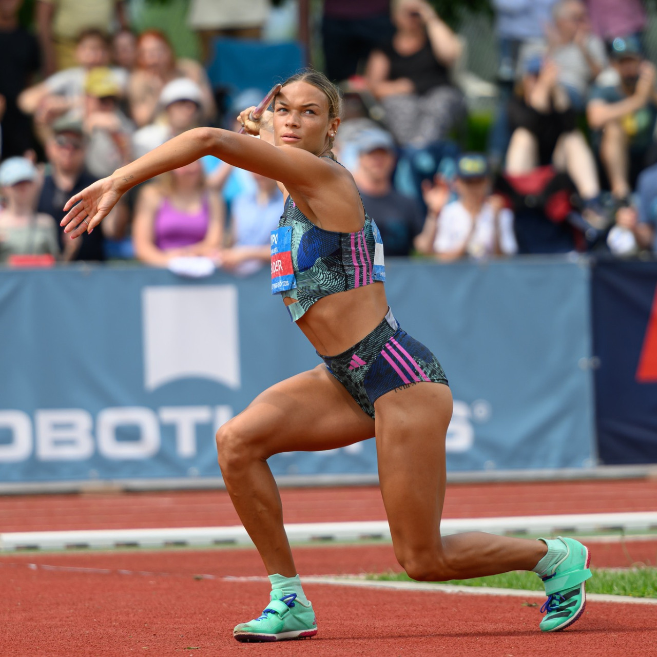Female athlete competing in track and field event on outdoor stadium track