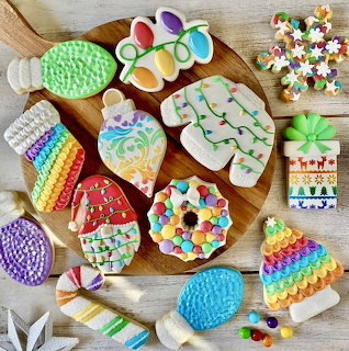 Assorted decorated Christmas cookies with colorful icing and candy toppings arranged on wooden table