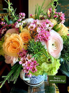 Colorful bouquet with roses, ranunculus, waxflowers, and green hydrangeas in a decorative vase