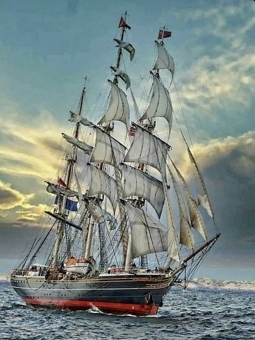 Tall ship Stad Amsterdam with white sails unfurled sailing on the ocean under cloudy skies