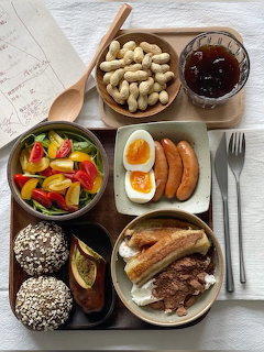 Korean meal with meat, eggs, sausages, vegetables, nuts, and rice cakes on wooden table