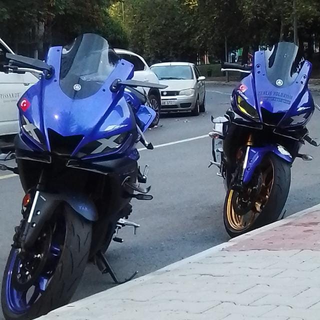 Two blue sport motorcycles parked on urban street