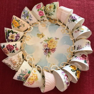 Wreath arrangement of vintage floral teacups displayed in a circle on an ornate plate