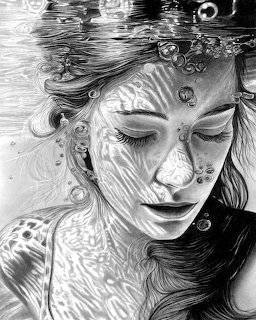 Black-and-white portrait of a woman underwater with closed eyes, bubbles, and flowing hair.
