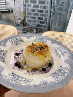 Panna cotta dessert with berries and honey on ornate plate