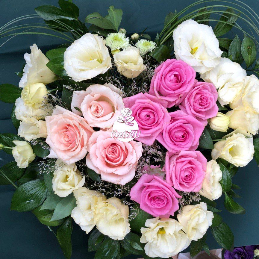 Heart-shaped bouquet with pink and white roses surrounded by white flowers and green leaves