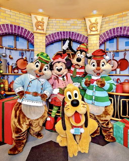 Disney characters in chef outfits posing together in a bright kitchen with yellow walls and purple arched windows