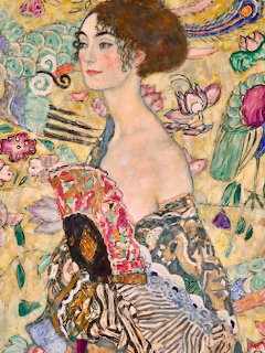 Portrait of woman in elegant dress holding ornate fan against decorative golden background with floral motifs